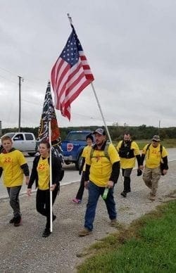 People in yellow shirts walking with American flag